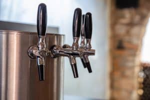 Beer taps in a row closeup, brew draft beer. Pub and brewery equipment